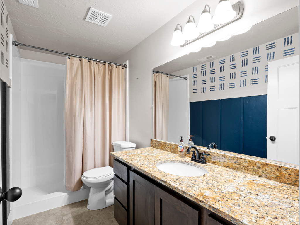 Full bathroom featuring toilet, a shower with shower curtain, visible vents, tile patterned flooring, and vanity
