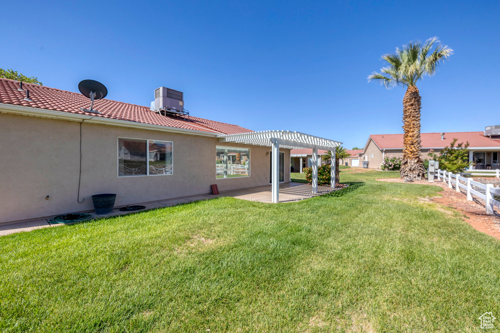 View of yard featuring central air condition unit, a patio area, a pergola, and fence