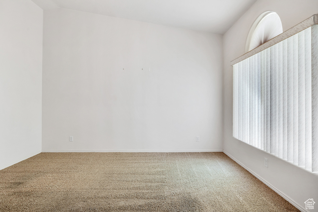 Empty room featuring baseboards and carpet