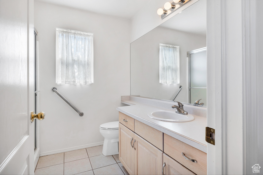 Full bath with toilet, a shower with door, baseboards, tile patterned flooring, and vanity