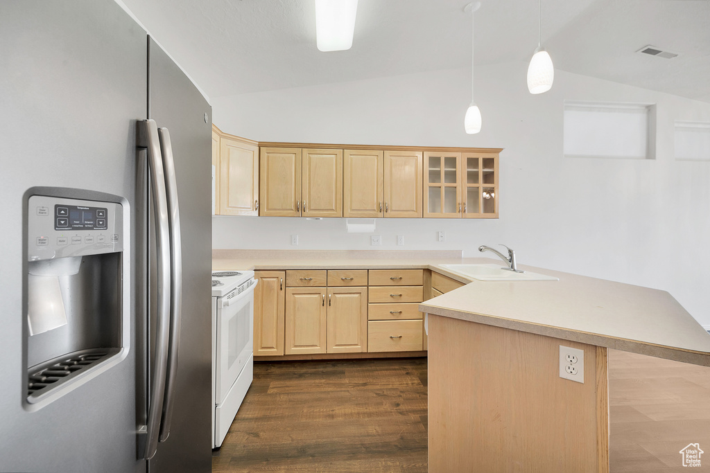 Kitchen with a sink, vaulted ceiling, light brown cabinetry, and stainless steel fridge