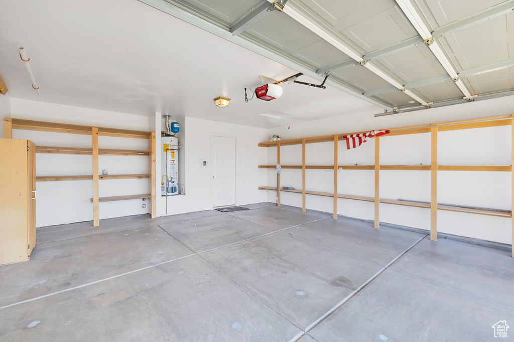 Garage featuring water heater and a garage door opener