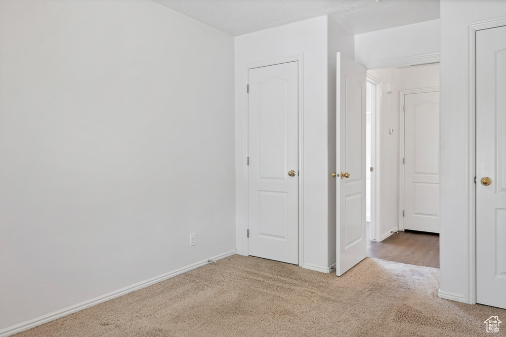 Unfurnished bedroom featuring carpet and baseboards