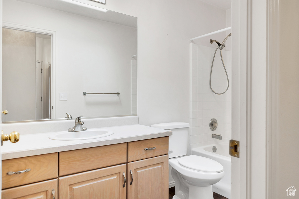 Bathroom with toilet, vanity, and shower / tub combination