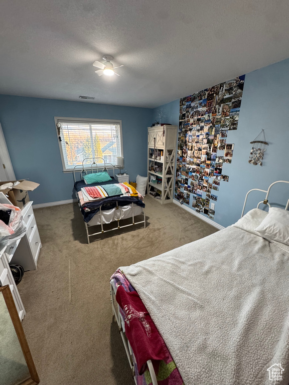 Bedroom with carpet, baseboards, visible vents, and a textured ceiling
