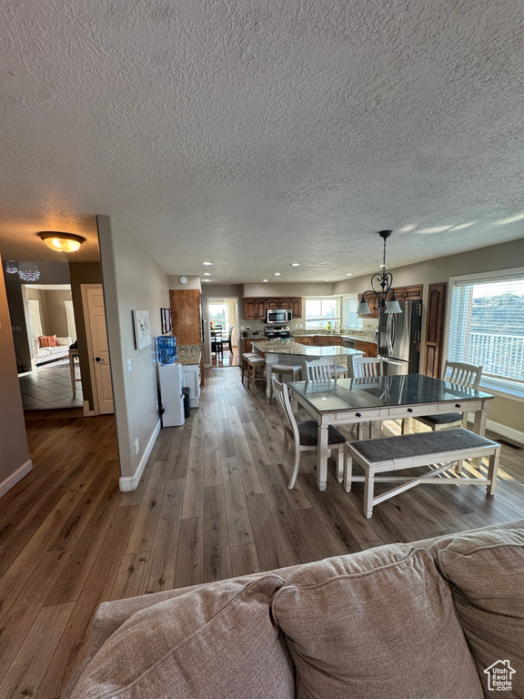 Living area featuring a textured ceiling, baseboards, and wood finished floors