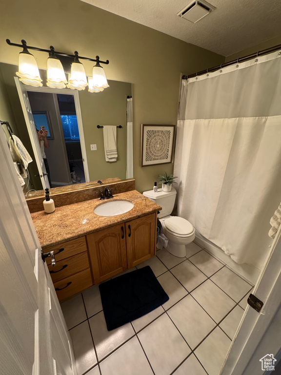 Full bathroom featuring toilet, tile patterned floors, vanity, and visible vents