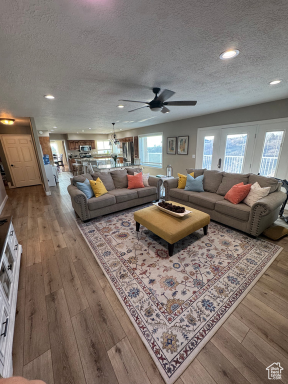 Living room with a textured ceiling, a ceiling fan, hardwood / wood-style floors, and recessed lighting