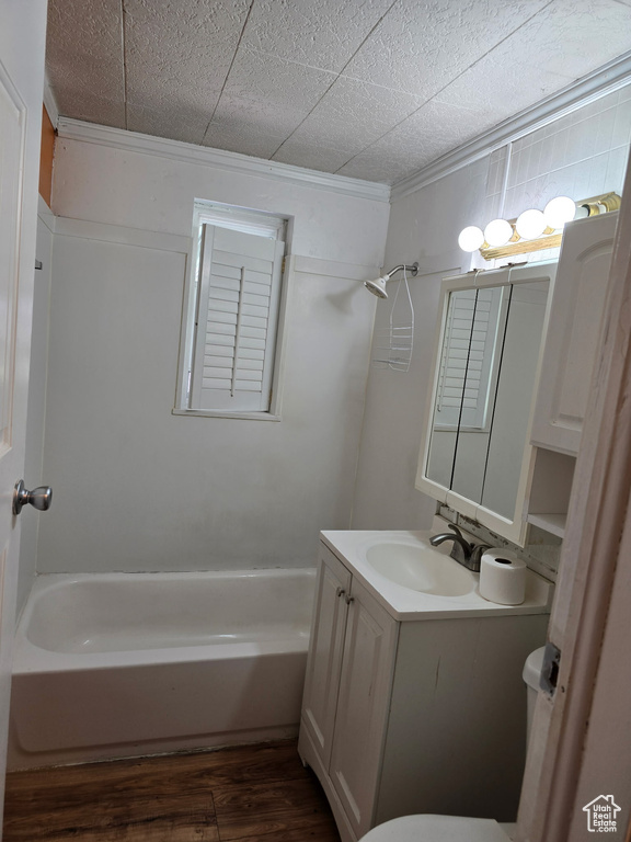 Full bathroom with vanity, ornamental molding, tub / shower combination, and wood finished floors