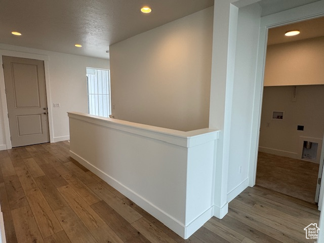 Hallway featuring baseboards, recessed lighting, and wood finished floors