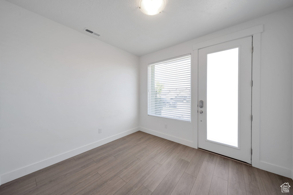 Entryway featuring baseboards, visible vents, and wood finished floors