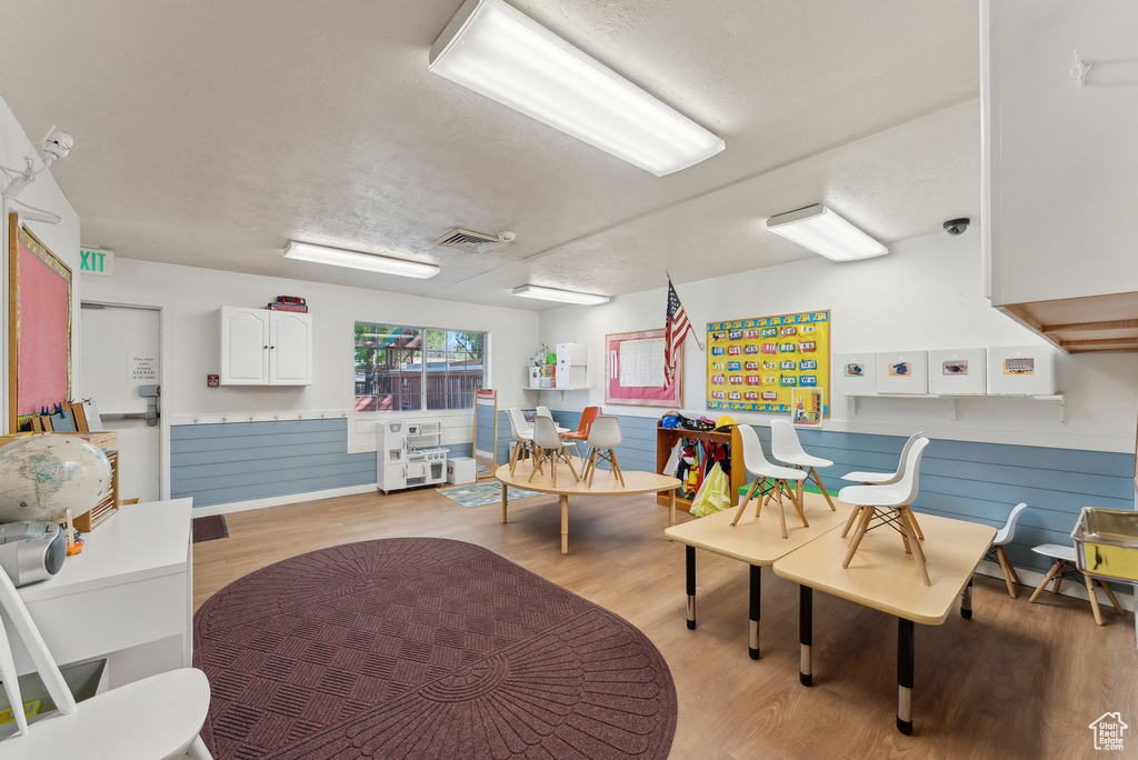 Interior space featuring a wainscoted wall, visible vents, and light wood-style floors
