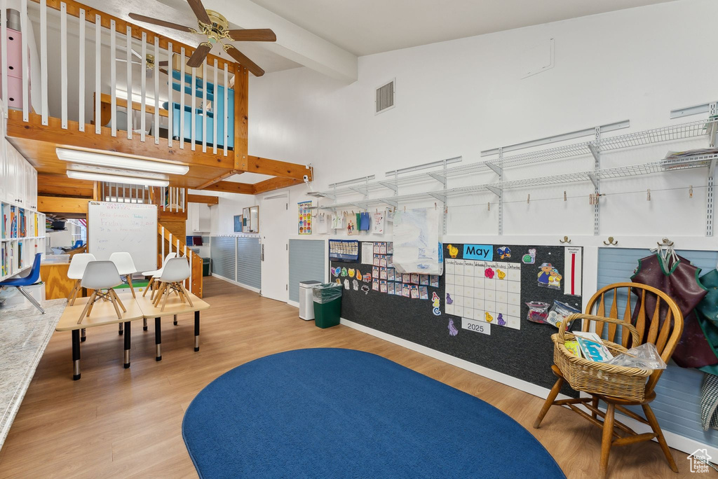 Sitting room with visible vents, wood finished floors, a towering ceiling, and ceiling fan