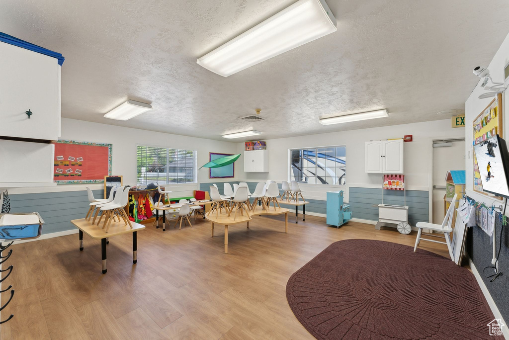 Interior space with a textured ceiling, visible vents, and light wood-style floors
