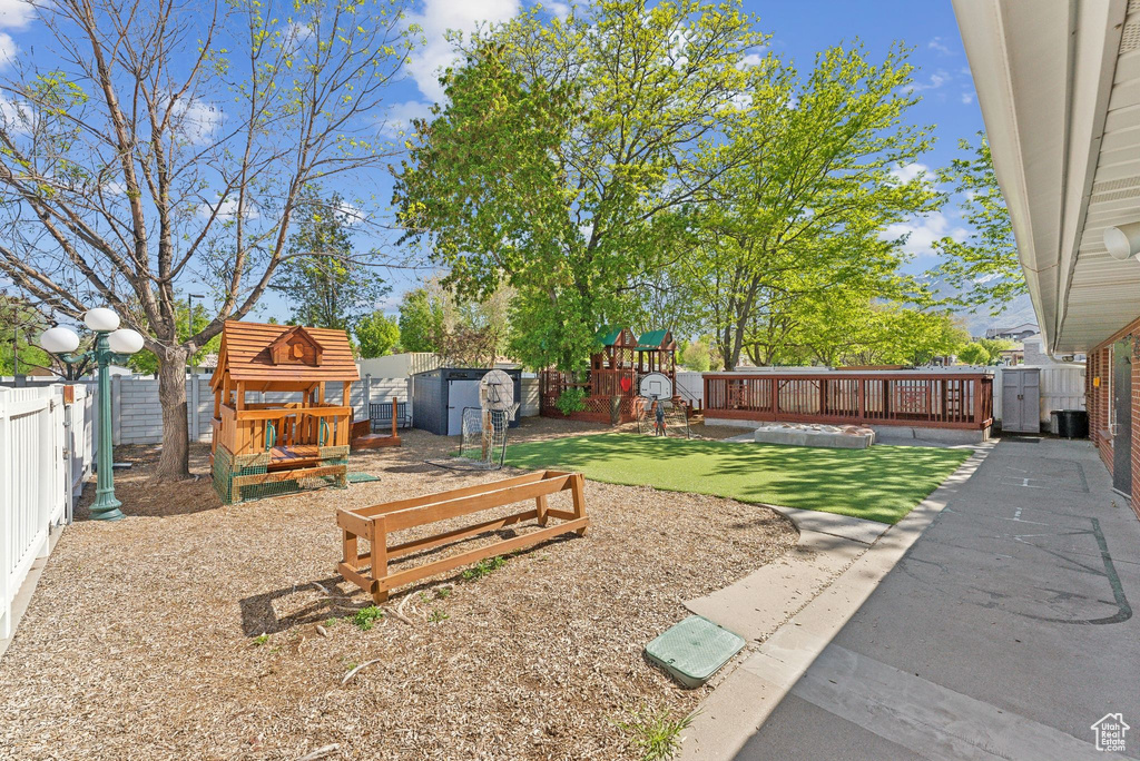View of yard with a playground and a fenced backyard