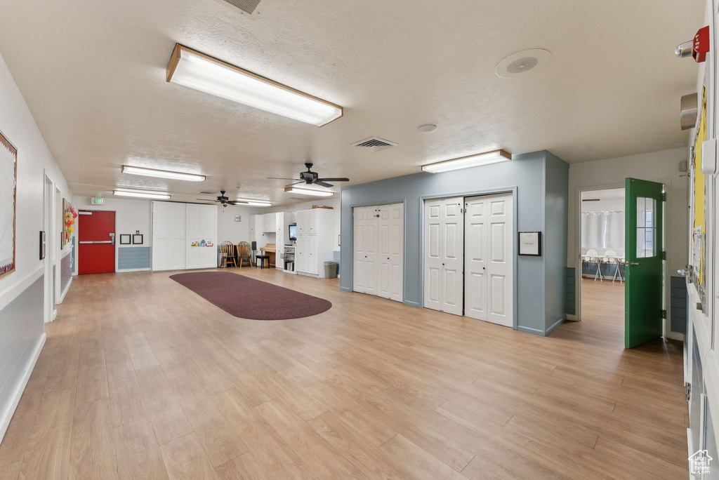 Interior space featuring light wood finished floors, baseboards, a ceiling fan, and visible vents