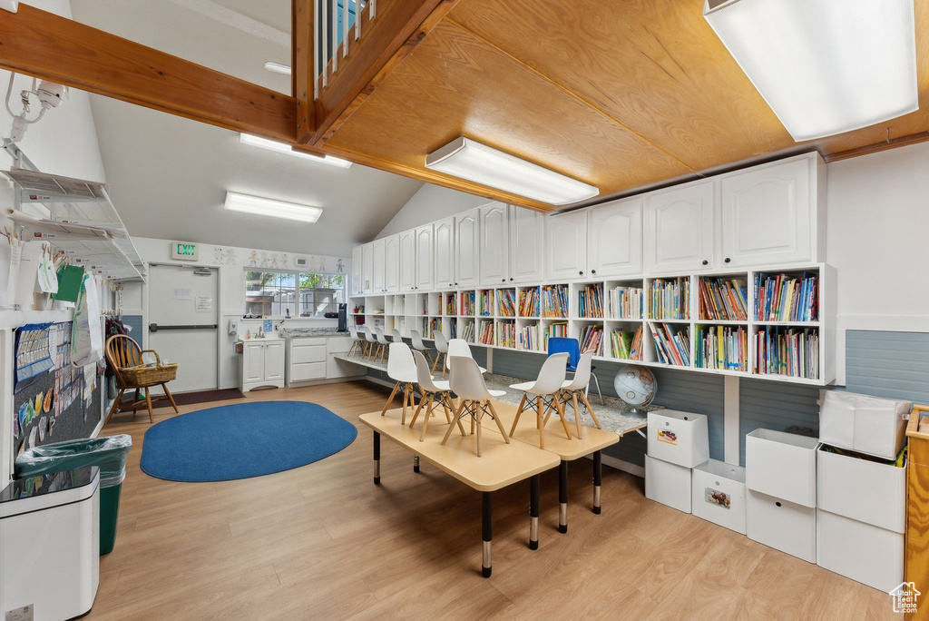 Office space with vaulted ceiling and light wood-style floors