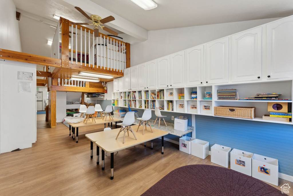 Living room with a ceiling fan, beamed ceiling, light wood-style flooring, and high vaulted ceiling