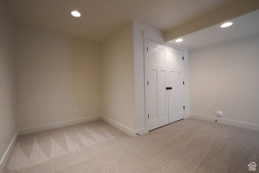 Interior space with light colored carpet, baseboards, and recessed lighting