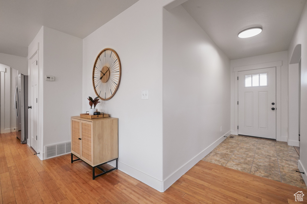 Foyer featuring light wood-type flooring, visible vents, and baseboards