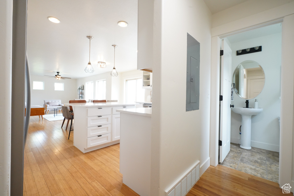 Hallway with recessed lighting, visible vents, and light wood-style floors