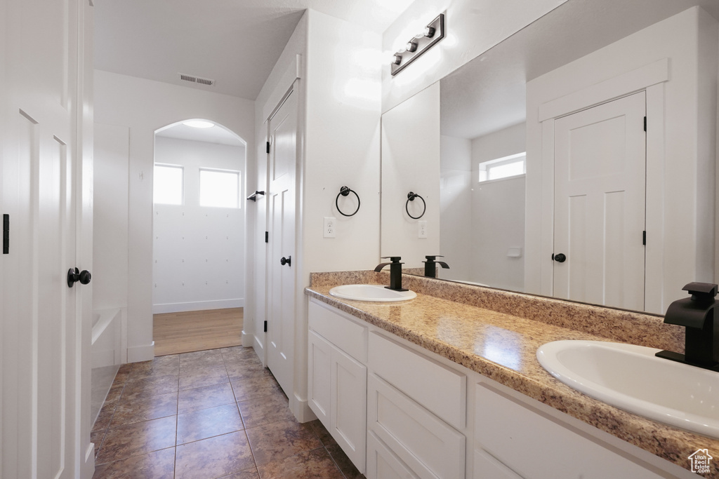 Full bathroom featuring a sink, double vanity, a bathtub, and visible vents