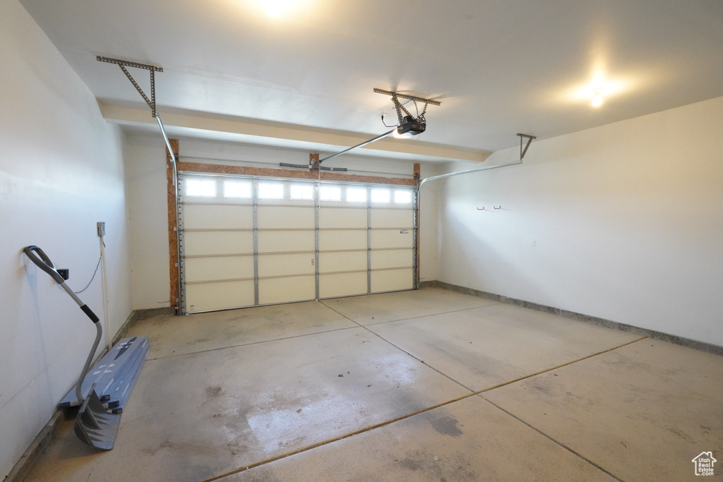 Garage with baseboards and a garage door opener