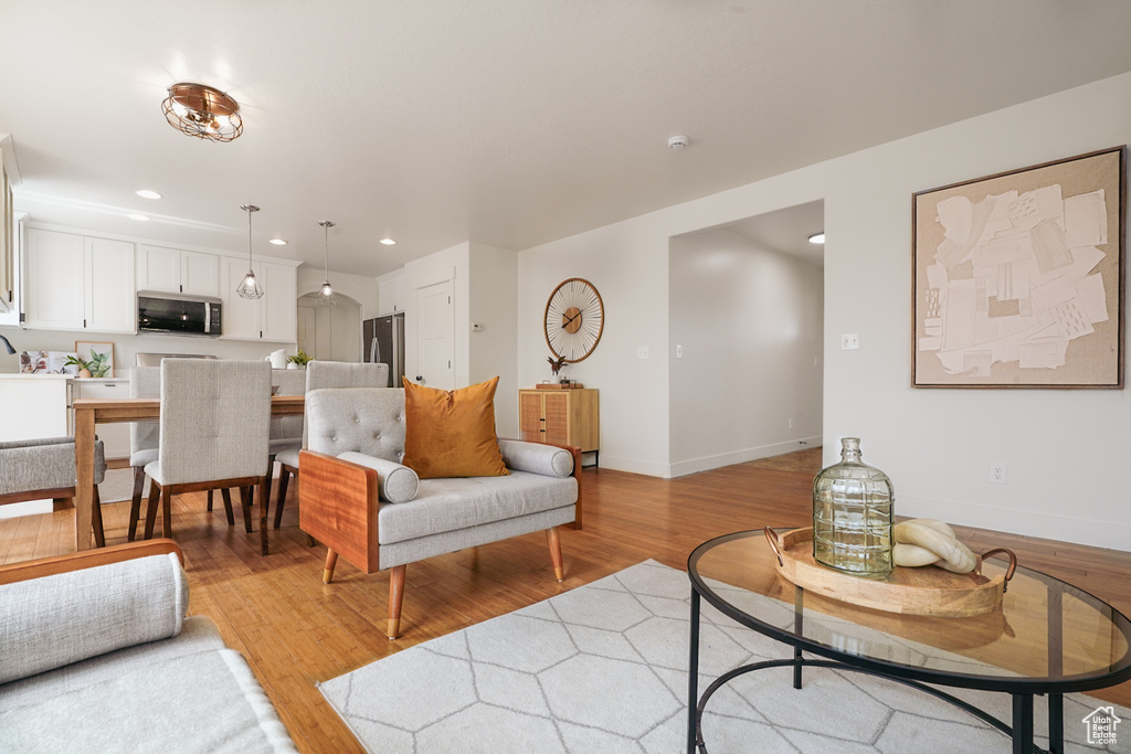 Living room featuring baseboards, light wood-type flooring, and recessed lighting