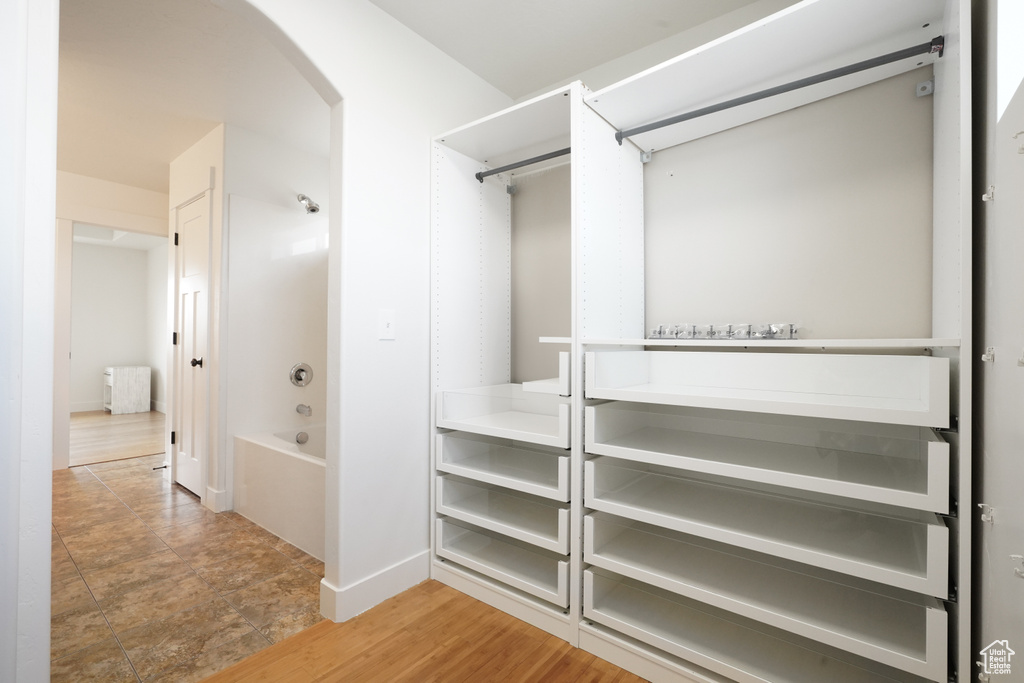 Walk in closet featuring arched walkways and radiator heating unit