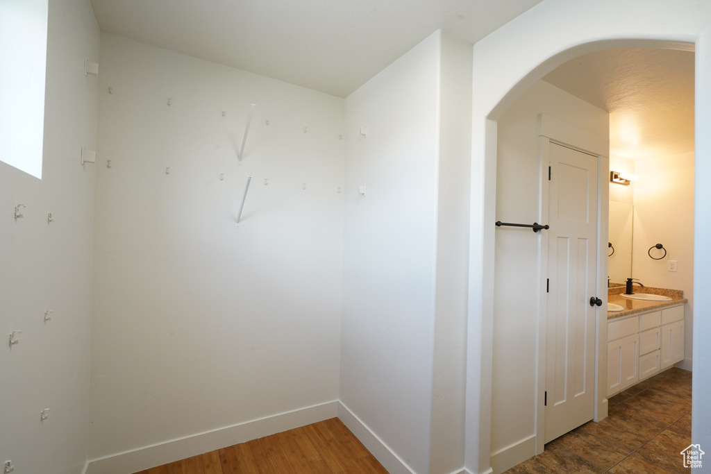 Interior space with baseboards, arched walkways, and a sink