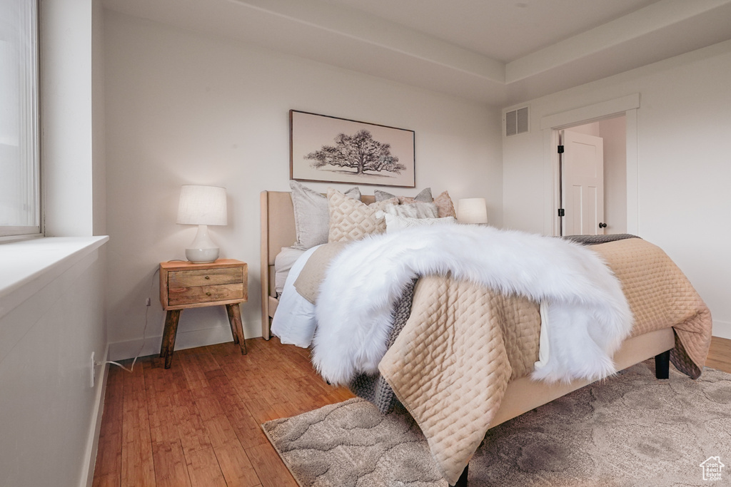 Bedroom with visible vents and hardwood / wood-style floors