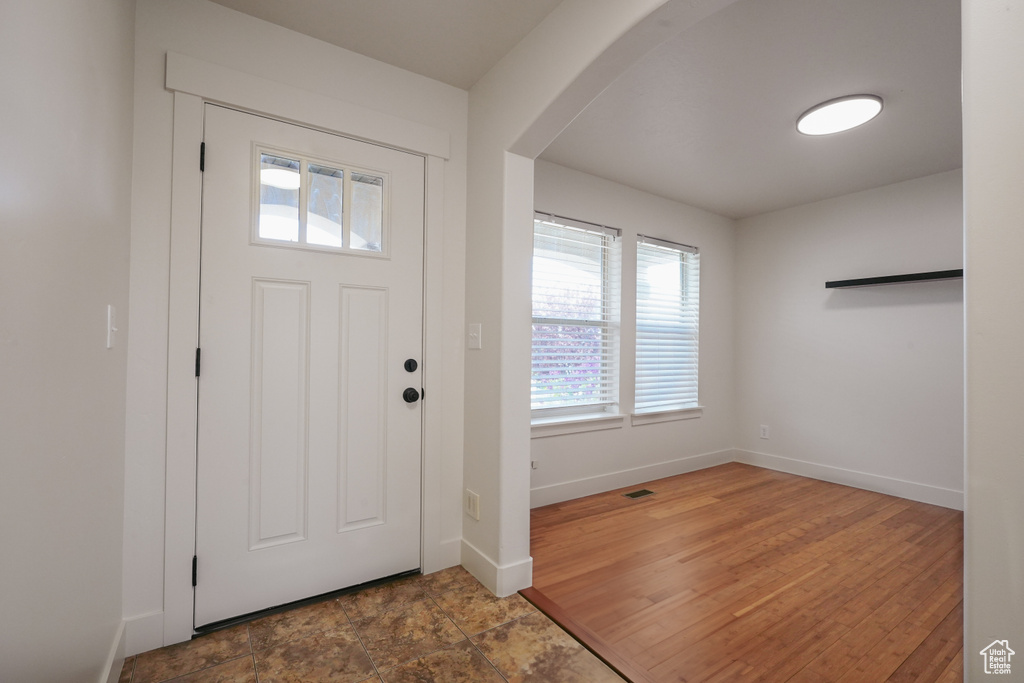 Foyer entrance featuring baseboards, a healthy amount of sunlight, visible vents, and arched walkways
