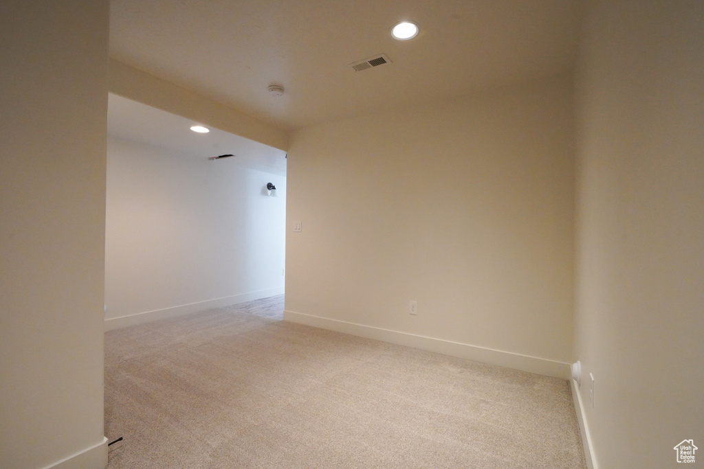 Spare room featuring light colored carpet, baseboards, and recessed lighting