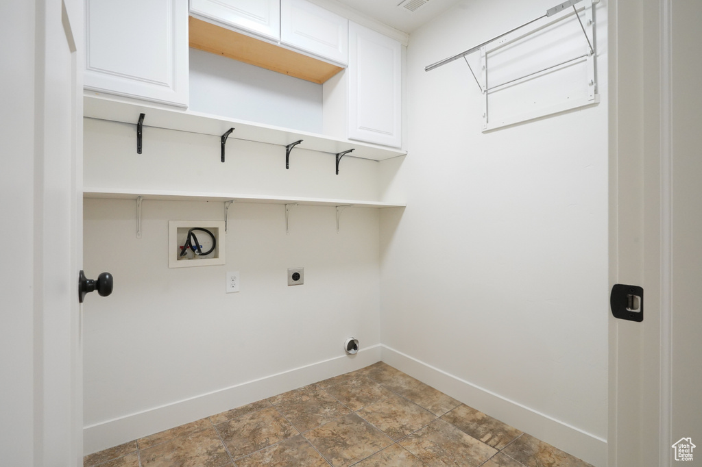 Washroom with baseboards, visible vents, washer hookup, cabinet space, and electric dryer hookup