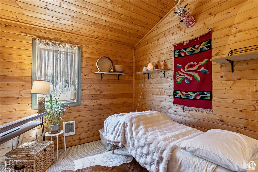 Bedroom with carpet, visible vents, wood ceiling, wooden walls, and vaulted ceiling