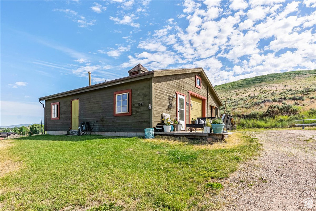 View of property exterior featuring a yard and a deck