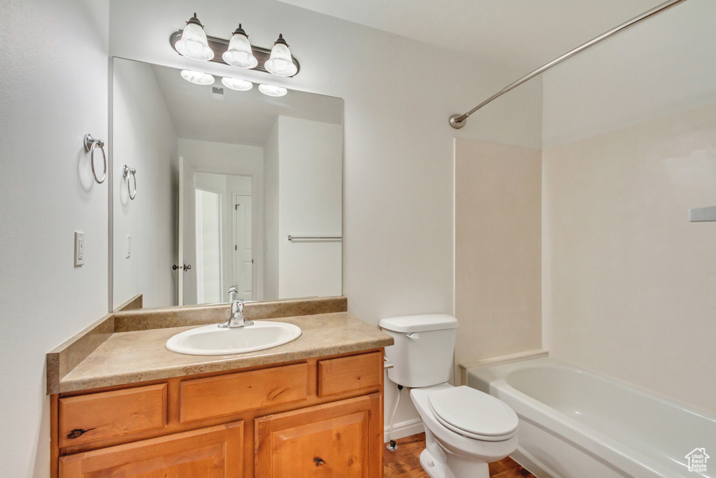 Full bath featuring toilet, vanity, tub / shower combination, and wood finished floors