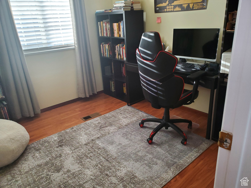 Home office with visible vents and wood finished floors