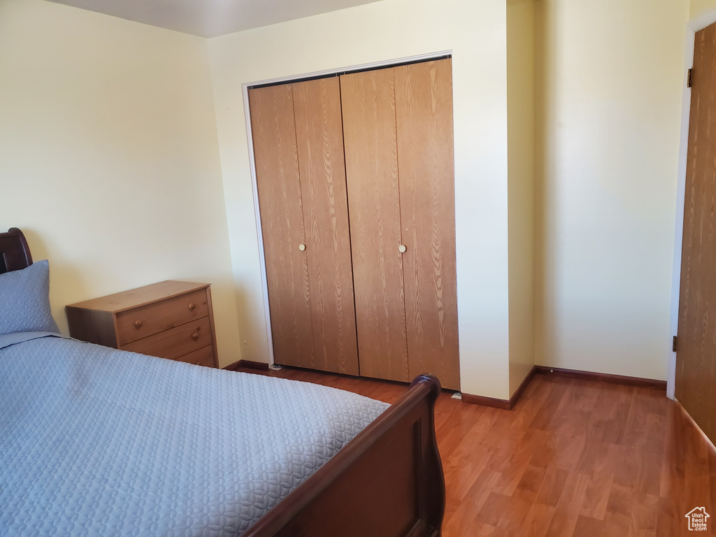 Bedroom with baseboards, a closet, and light wood-type flooring