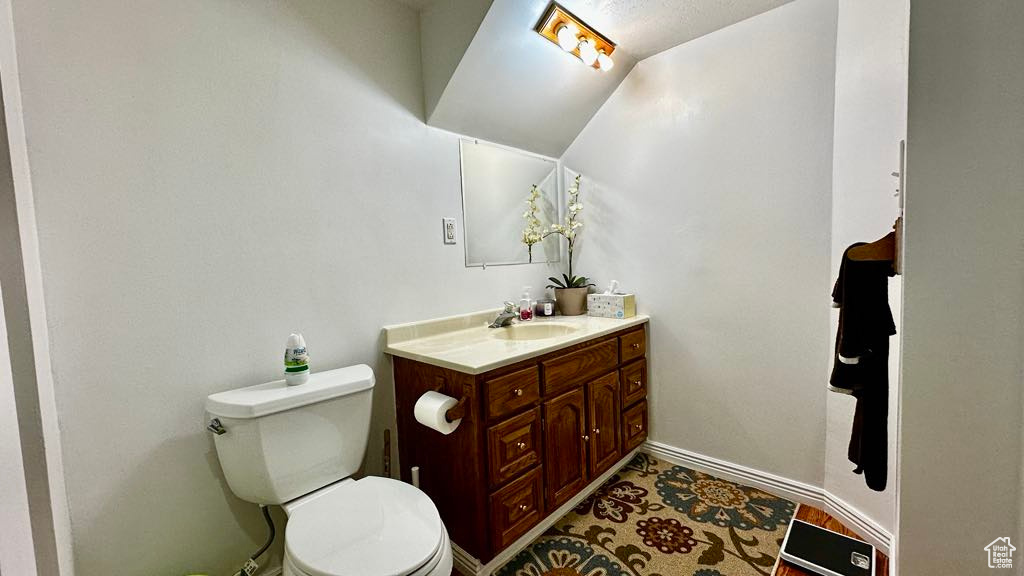 Bathroom with vanity, toilet, and baseboards
