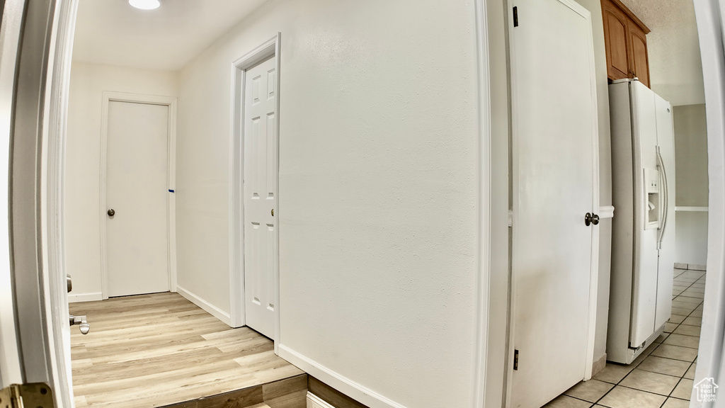 Hallway featuring baseboards and light tile patterned floors