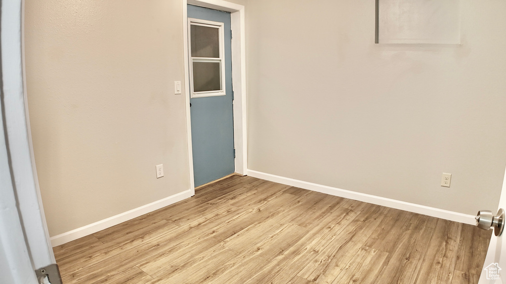 Spare room featuring baseboards and light wood-style floors