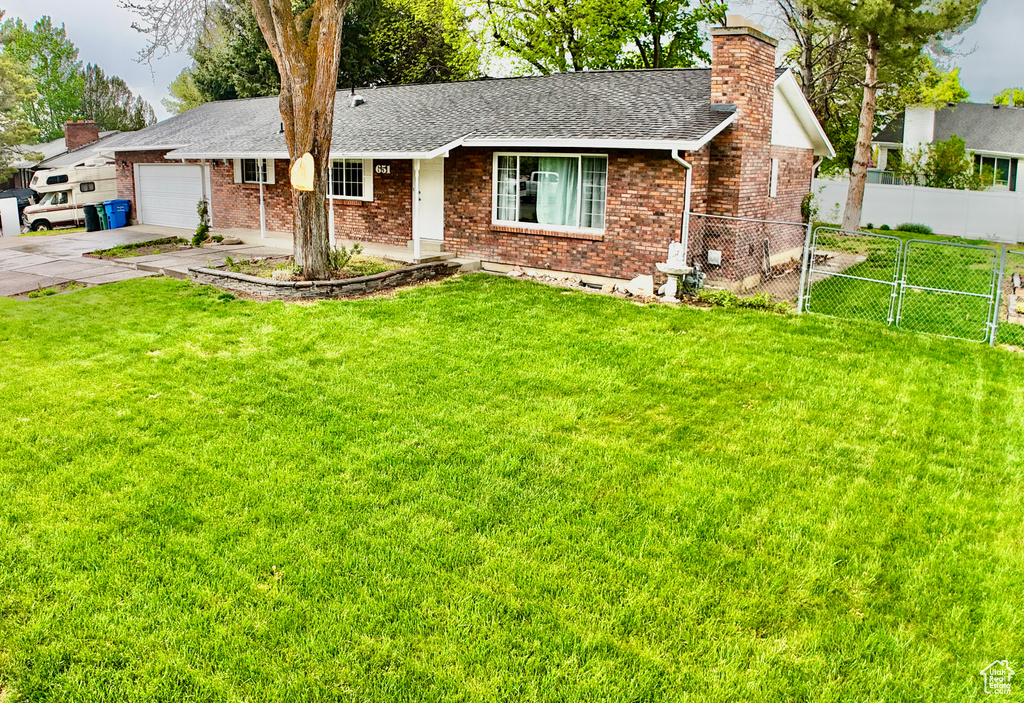 Single story home featuring fence, a chimney, concrete driveway, and brick siding