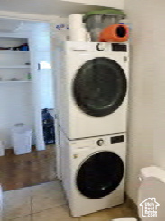 Laundry area featuring laundry area, tile patterned floors, and stacked washer / drying machine
