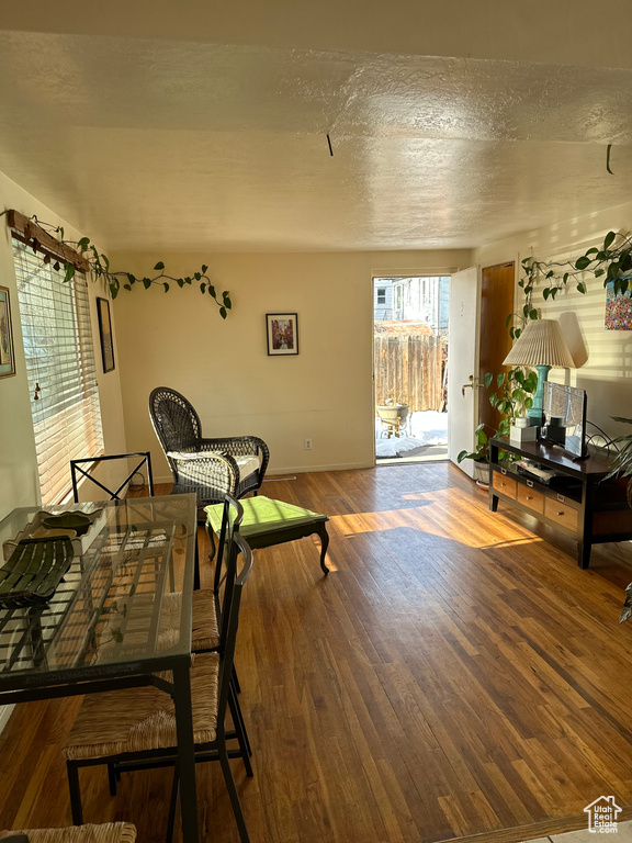 Living area with baseboards, a textured ceiling, and wood finished floors