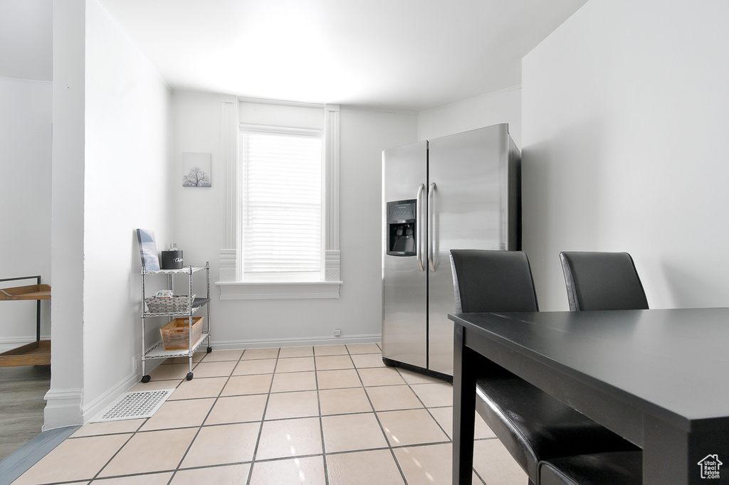 Interior space with visible vents, baseboards, and stainless steel fridge with ice dispenser