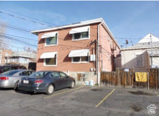 View of front of home featuring fence and uncovered parking