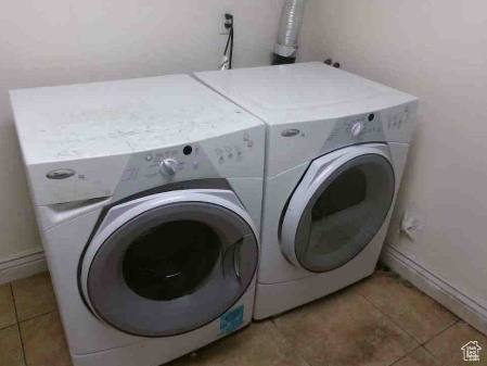 Laundry room featuring washer and dryer, laundry area, baseboards, and light tile patterned floors