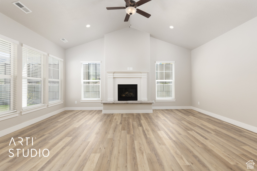 Unfurnished living room with ceiling fan, plenty of natural light, and visible vents