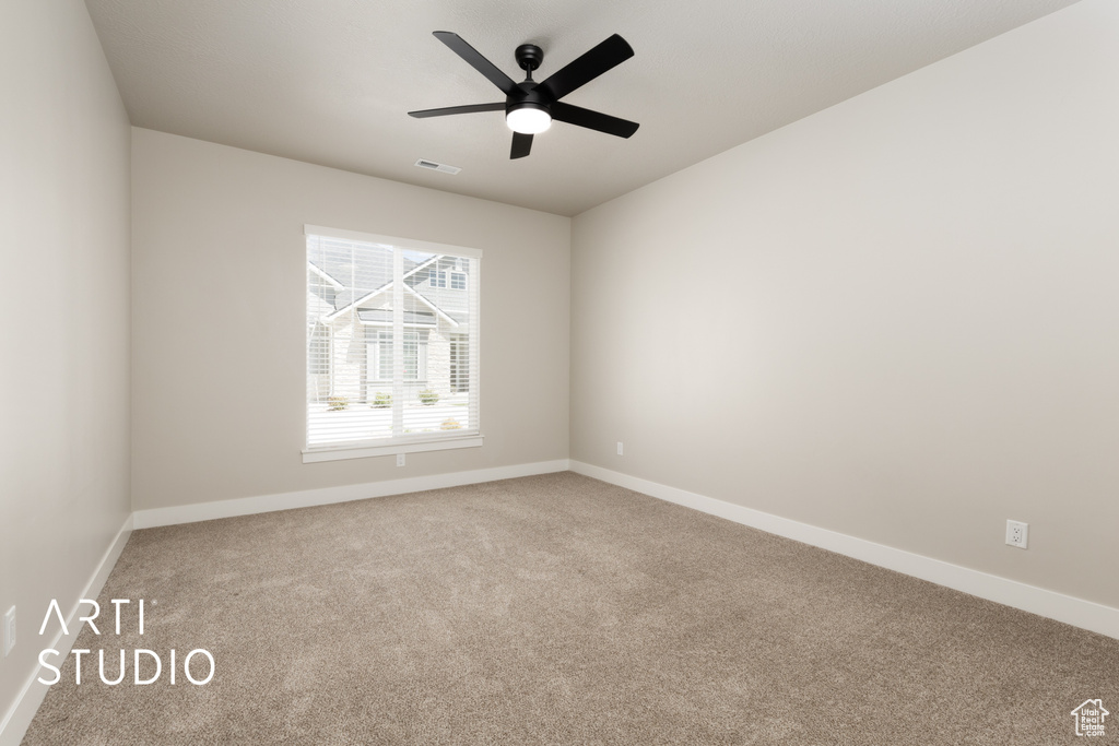 Spare room featuring carpet flooring, baseboards, a ceiling fan, and visible vents